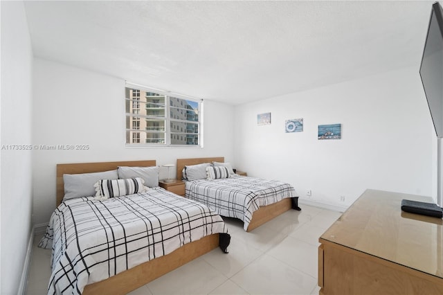 bedroom featuring light tile patterned floors and baseboards