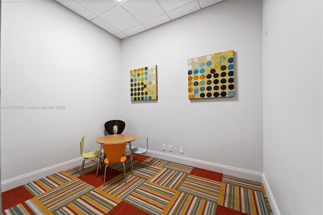 carpeted home office with a drop ceiling and baseboards