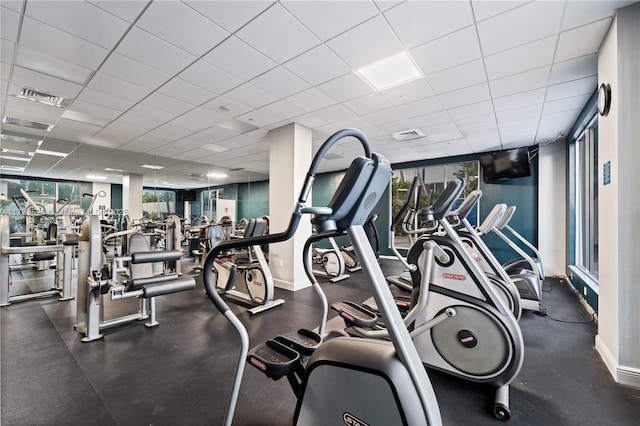 workout area featuring baseboards, visible vents, and a drop ceiling