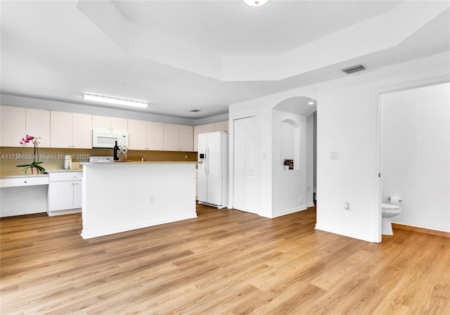 living room featuring light hardwood / wood-style flooring and a tray ceiling