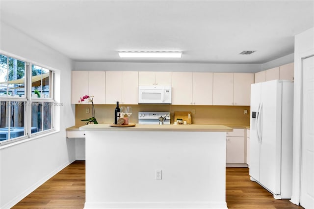 kitchen featuring white appliances, light hardwood / wood-style floors, white cabinets, and a kitchen island