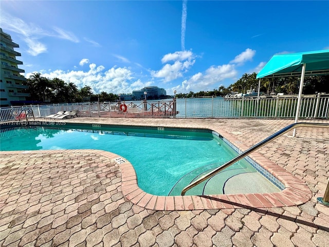 view of pool featuring a patio area and a water view