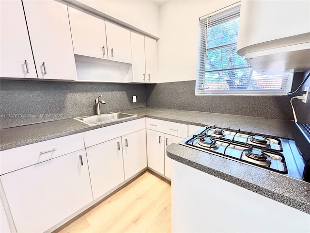 kitchen featuring light wood-type flooring, gas cooktop, sink, and white cabinets