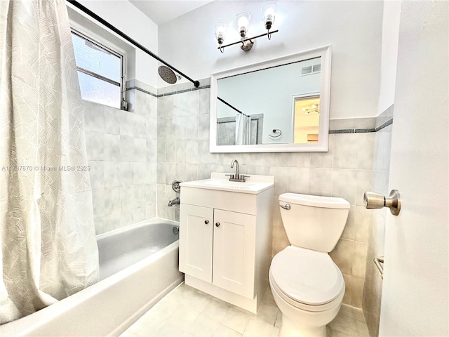 full bathroom with tile walls, vanity, toilet, and shower / bathtub combination with curtain