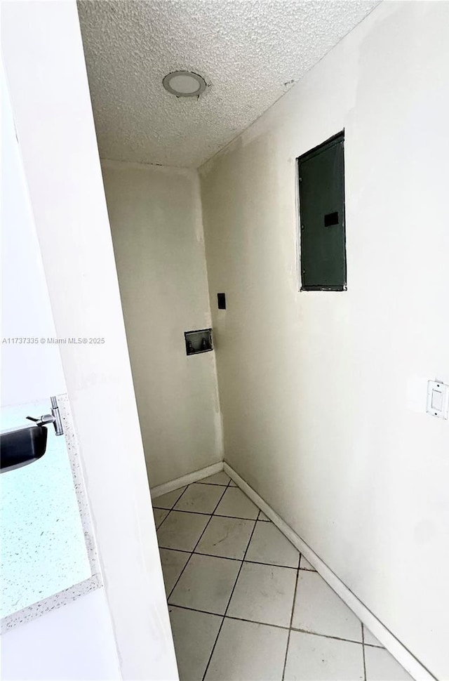 corridor featuring tile patterned floors, sink, and a textured ceiling