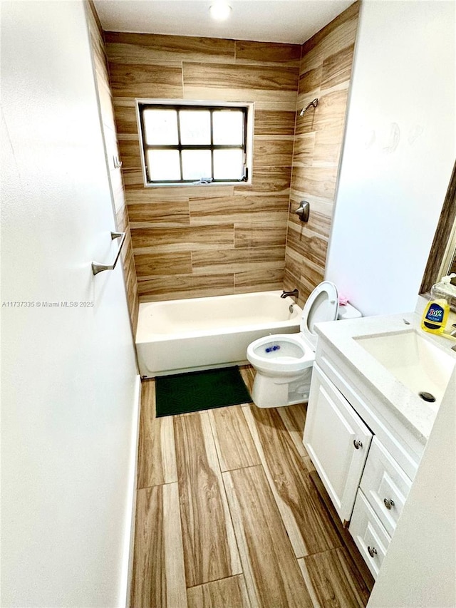 full bathroom with vanity, tiled shower / bath combo, and toilet