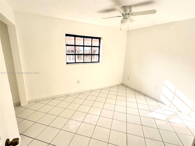 spare room featuring ceiling fan, a textured ceiling, and light tile patterned floors