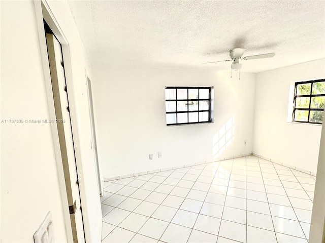 tiled empty room with a textured ceiling and ceiling fan