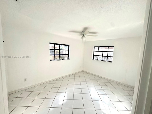 spare room with light tile patterned flooring, a textured ceiling, and ceiling fan