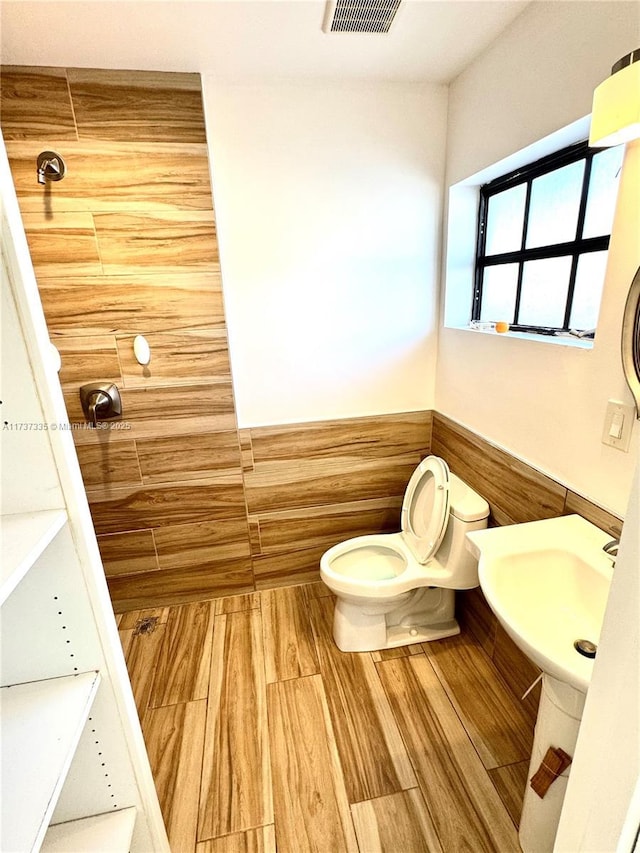 bathroom with hardwood / wood-style floors and toilet