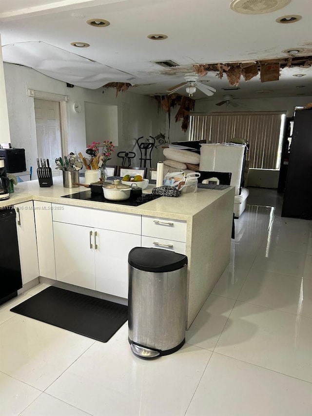 kitchen with light tile patterned floors, black dishwasher, white cabinets, and ceiling fan