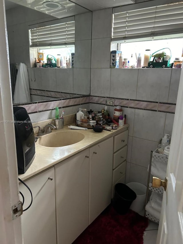 bathroom featuring vanity and tile walls