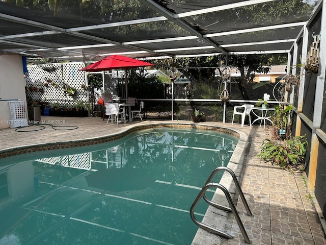 view of swimming pool featuring a patio and a lanai