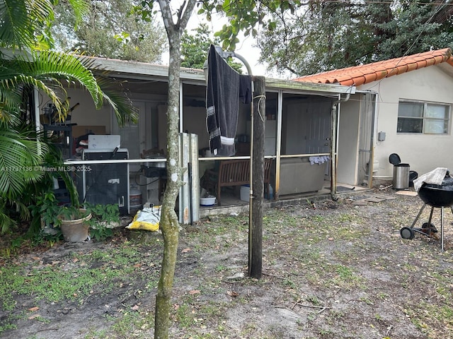 rear view of property featuring a sunroom