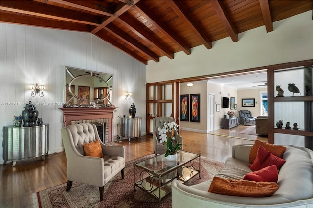 living room featuring a tiled fireplace, vaulted ceiling with beams, hardwood / wood-style floors, and wooden ceiling