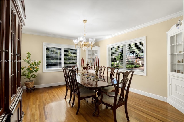 dining area featuring crown molding, an inviting chandelier, and light hardwood / wood-style flooring