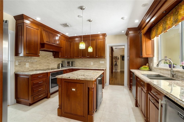 kitchen featuring sink, light stone counters, a kitchen island, pendant lighting, and stainless steel appliances