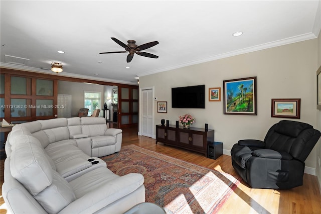 living room featuring ornamental molding, ceiling fan, and light hardwood / wood-style flooring