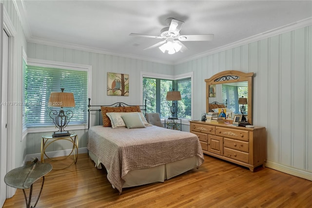 bedroom with crown molding, ceiling fan, and wood-type flooring