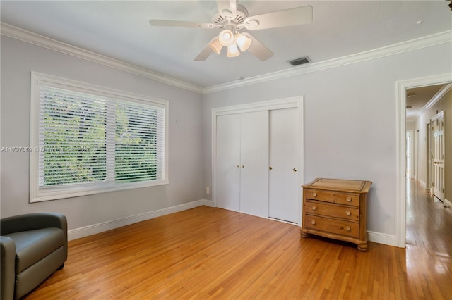 bedroom with crown molding, ceiling fan, hardwood / wood-style floors, and a closet