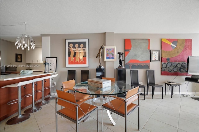 dining area with light tile patterned flooring, a textured ceiling, and an inviting chandelier