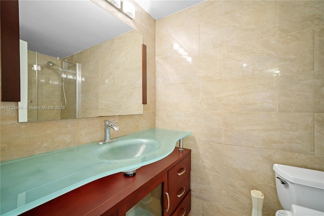 bathroom with vanity, toilet, tile walls, and a tile shower