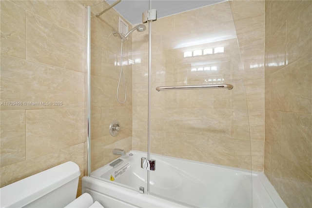 bathroom with toilet and tiled shower / bath combo