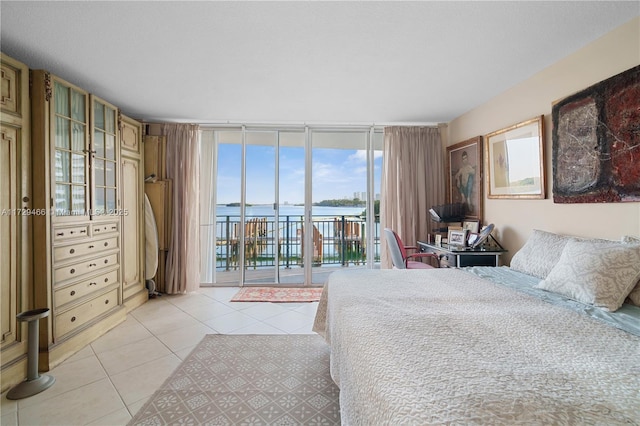 bedroom with expansive windows, access to exterior, and light tile patterned floors