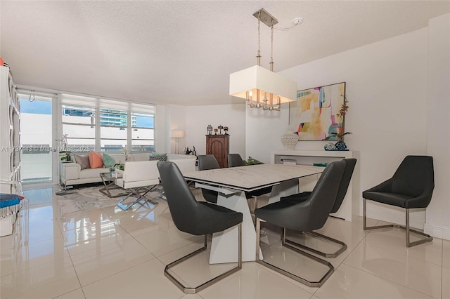 dining space with expansive windows, a notable chandelier, a textured ceiling, and light tile patterned floors