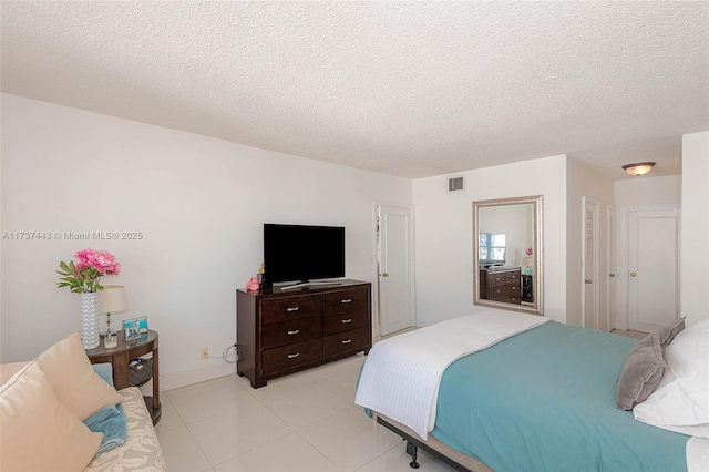 bedroom featuring light tile patterned floors and a textured ceiling