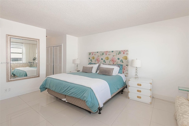 bedroom featuring light tile patterned floors, a textured ceiling, and a closet