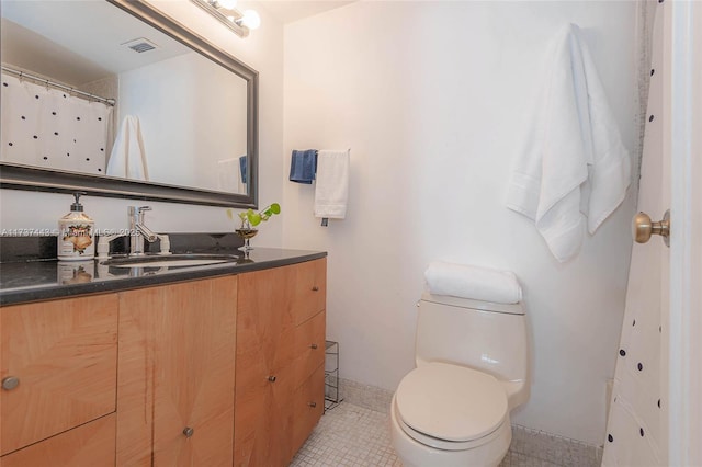 bathroom featuring tile patterned floors, vanity, and toilet