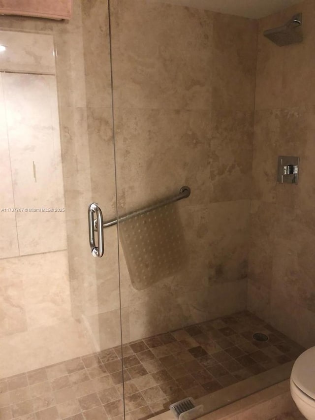 full bathroom featuring a stall shower and toilet