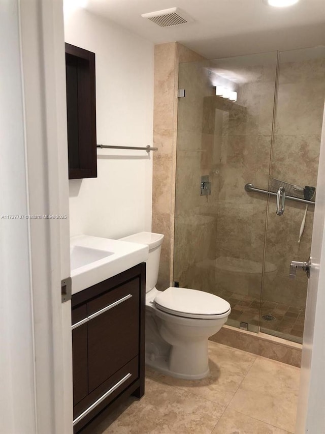 full bathroom featuring toilet, a stall shower, visible vents, and vanity