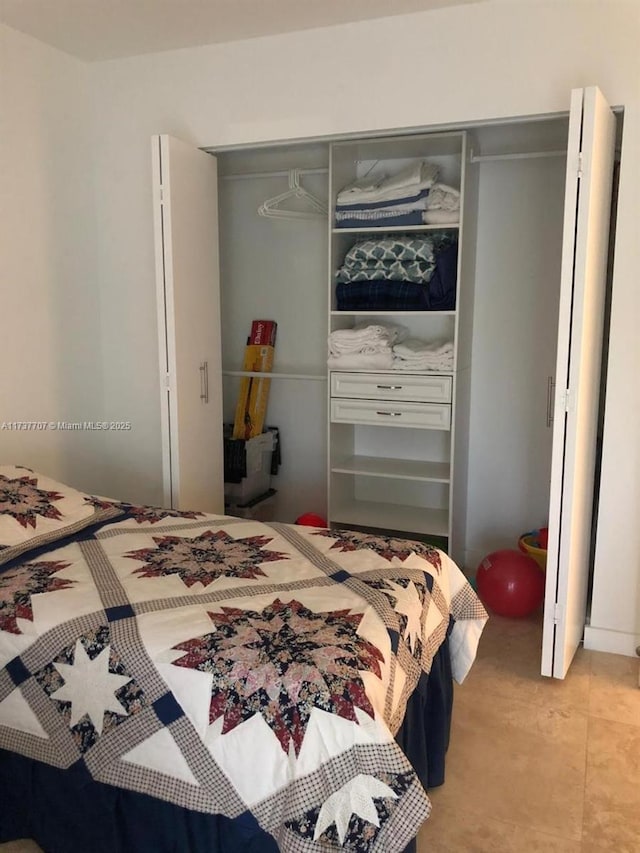 bedroom featuring light tile patterned floors and a closet