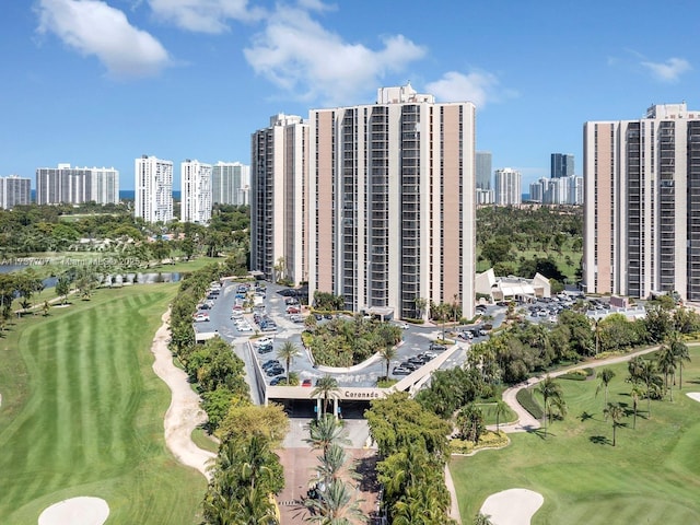 drone / aerial view with view of golf course and a city view