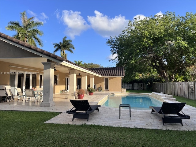 view of pool with ceiling fan, a patio area, and a lawn