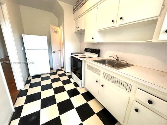 kitchen featuring electric stove, sink, white cabinets, and white refrigerator