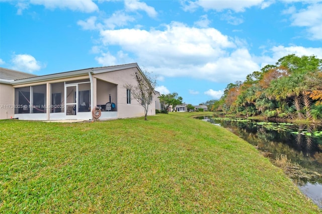 view of yard with a water view and a sunroom