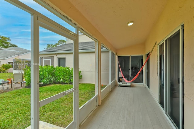 unfurnished sunroom featuring vaulted ceiling