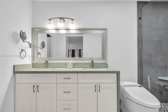 bathroom with vanity, toilet, and tiled shower