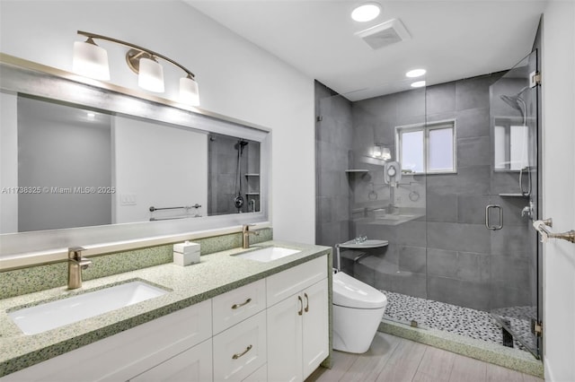 bathroom featuring toilet, hardwood / wood-style floors, vanity, and walk in shower