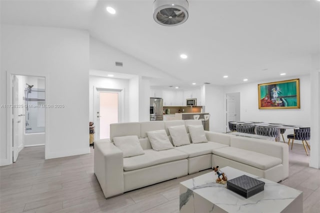 living room featuring lofted ceiling and light hardwood / wood-style flooring