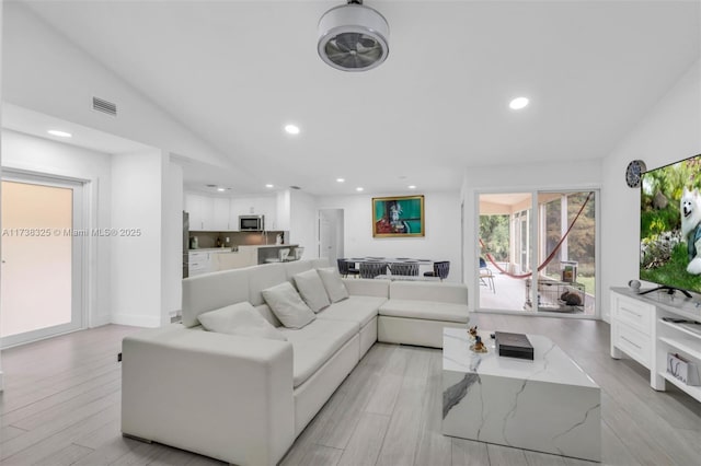 living room featuring vaulted ceiling and light hardwood / wood-style floors