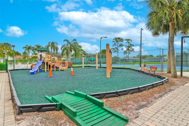 view of jungle gym featuring tennis court