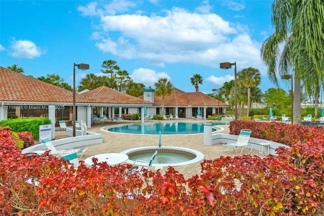 view of pool with a hot tub and a patio