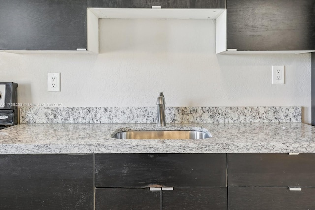 kitchen with light stone countertops and sink