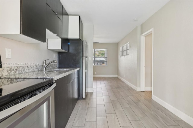 kitchen featuring white cabinetry, stainless steel range with electric stovetop, and sink