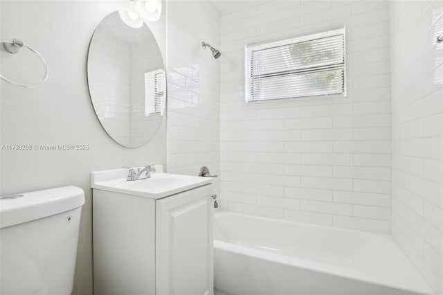 full bathroom featuring vanity, tiled shower / bath, and toilet