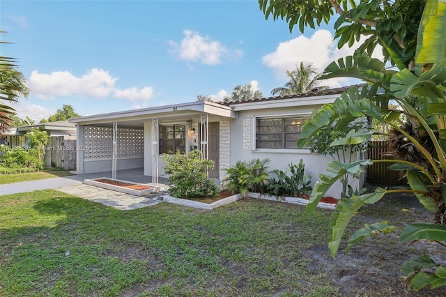 view of front of property with a carport and a front lawn